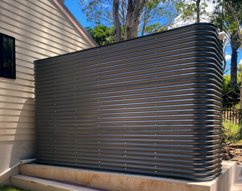 a large ccwt modline tank sitting on a concrete tank pad outside of a building